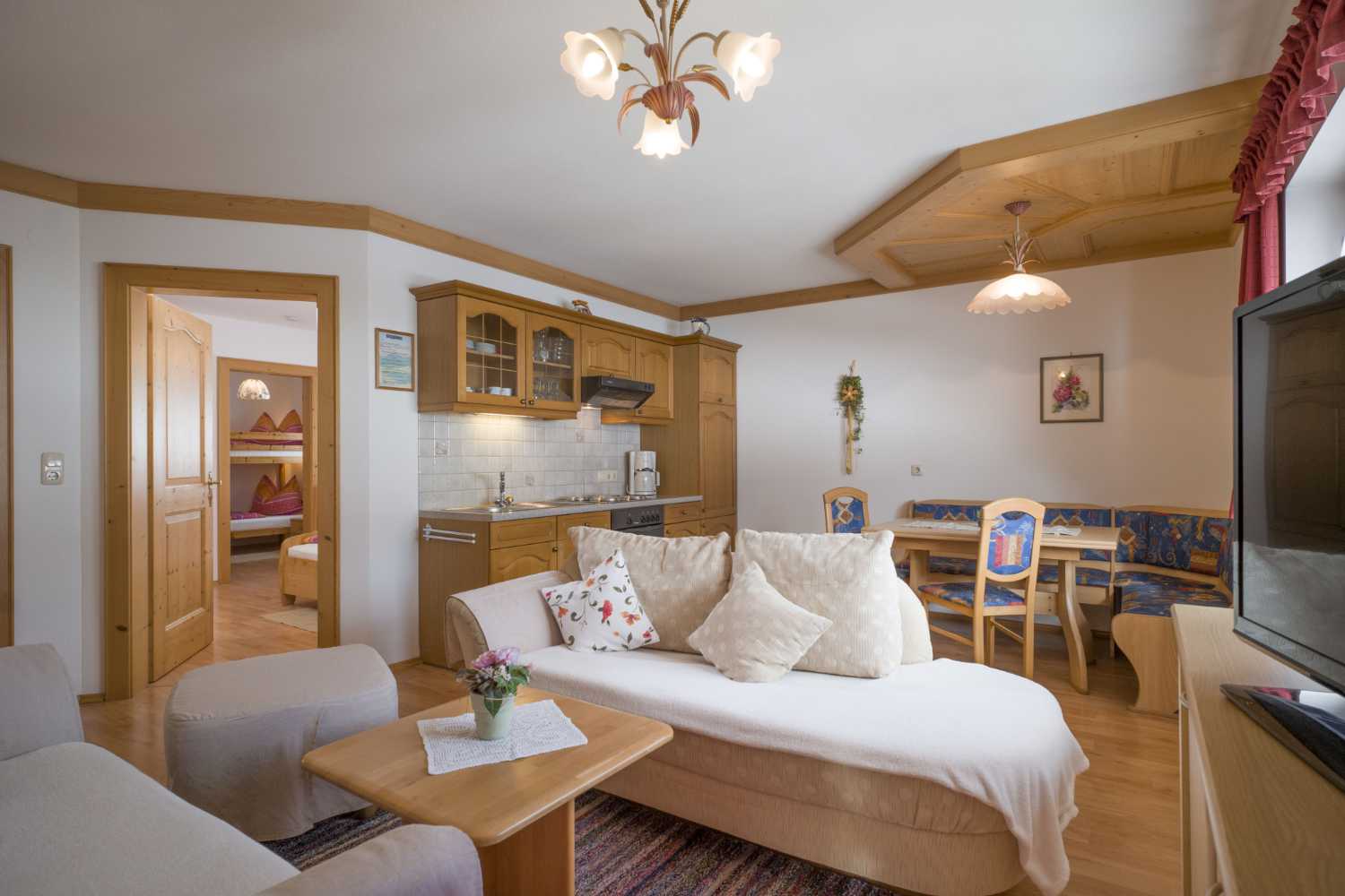 Wohnbereich im Appartementhaus Planer in Schwendt im Kaiserwinkl mit Sofa, Couchtisch und TV