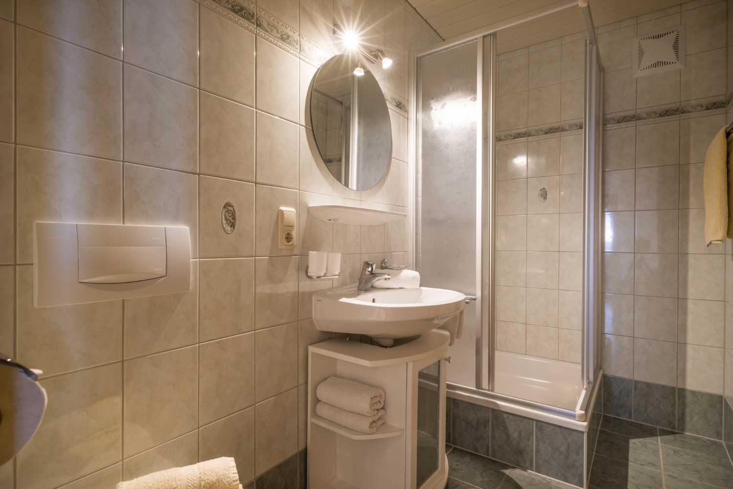 Dusche und Waschbecken im Badezimmer im Appartementhaus Planer in Schwendt im Kaiserwinkl