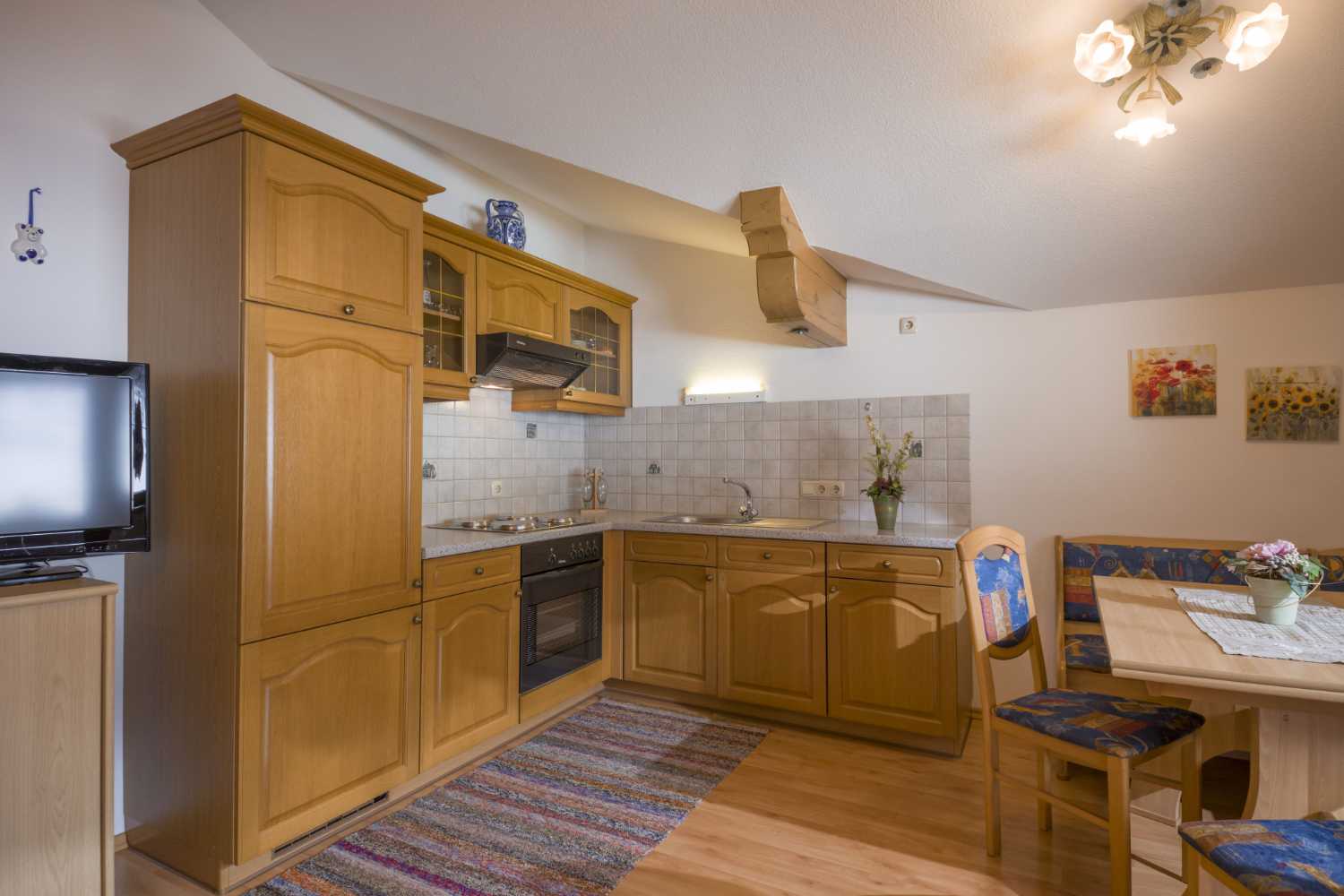 Küchenbereich im Appartementhaus Planer in Schwendt im Kaiserwinkl mit Holzfronten und Essplatz