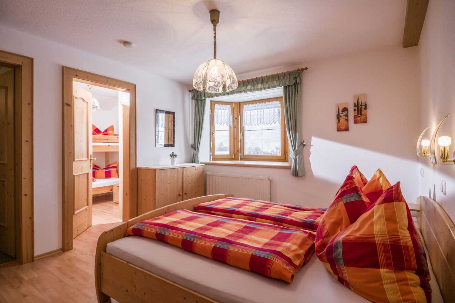 Schlafzimmer im Appartementhaus Planer in Schwendt im Kaiserwinkl mit Fenster, Holzvertäfelung und Doppelbett
