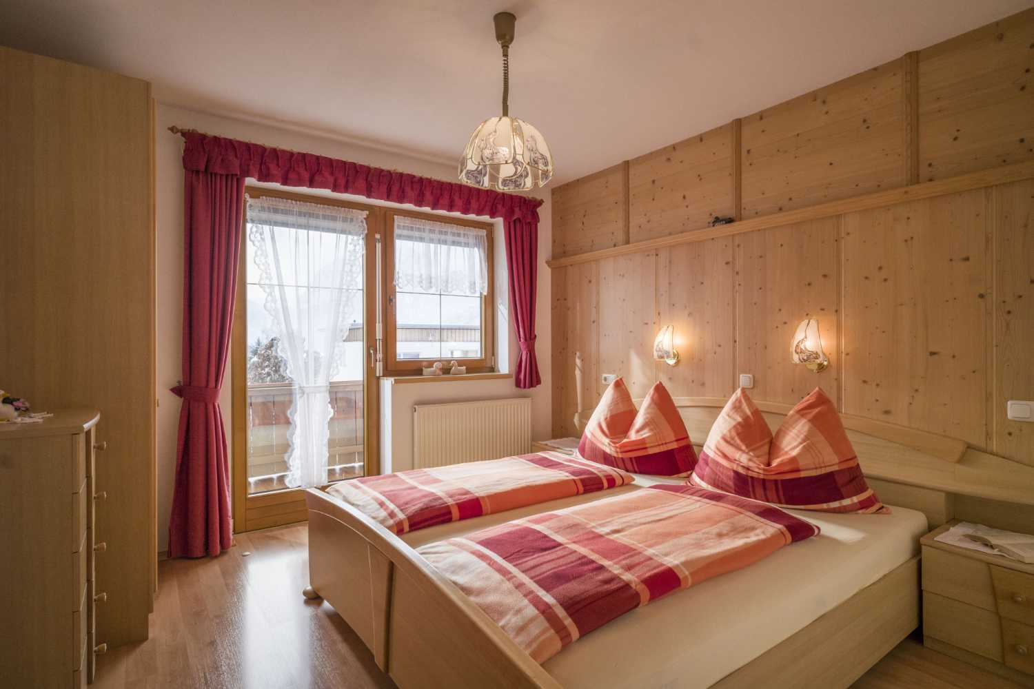 Schlafzimmer im Appartementhaus Planer in Schwendt im Kaiserwinkl mit Doppelbett und Tiroler Einrichtung