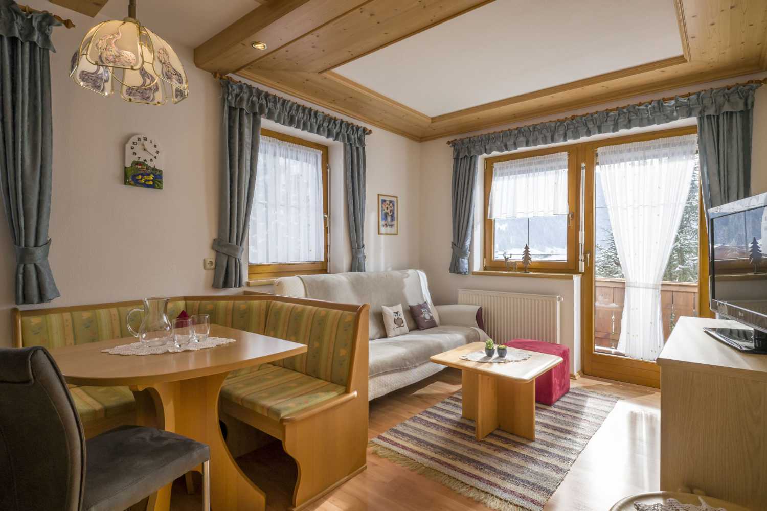 Wohnbereich im Appartementhaus Planer in Schwendt im Kaiserwinkl mit Sofa, Couchtisch und TV