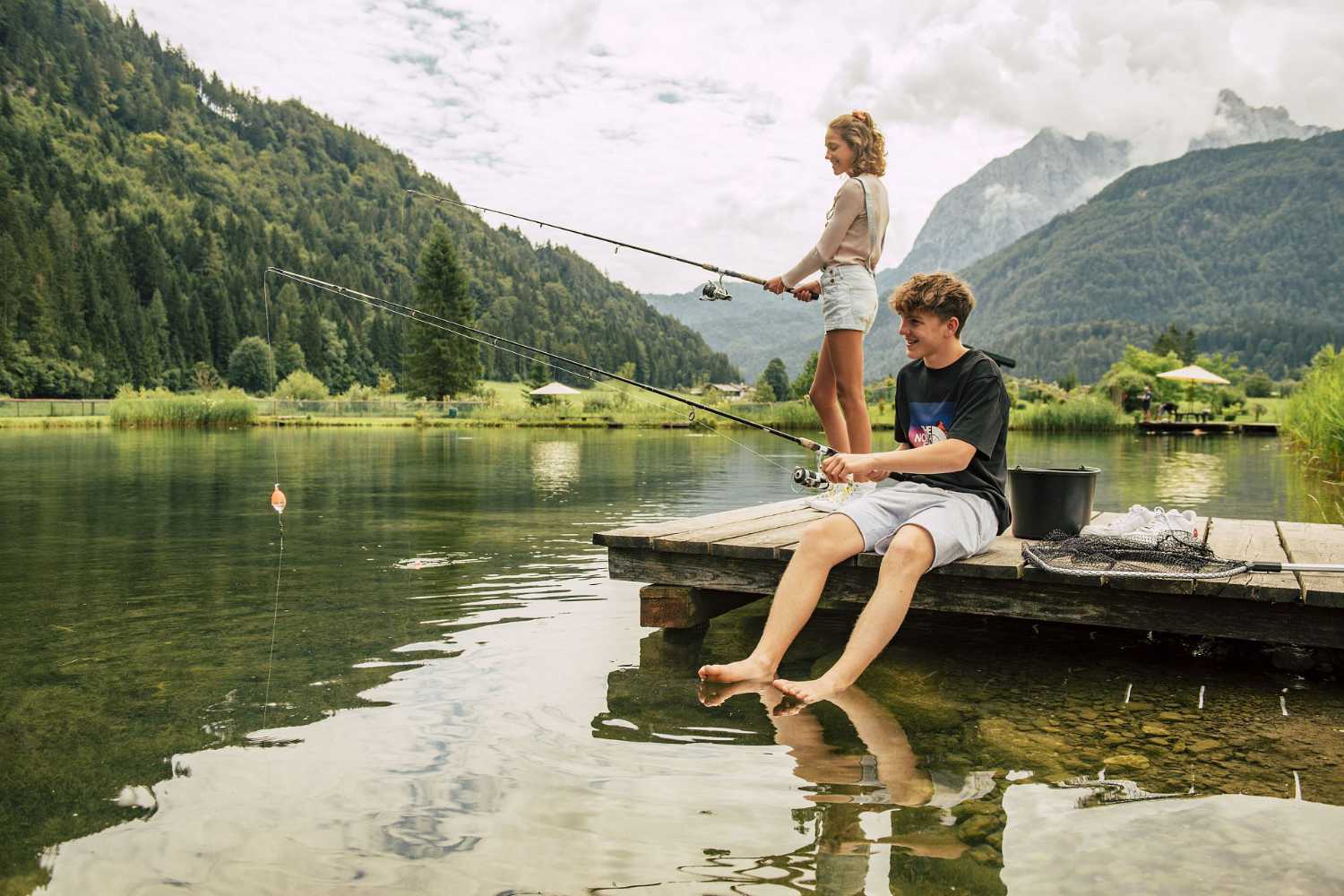 Angeln im Kaiserwinkl in Tirol: Angeln am See vom Steg mit Bergblick