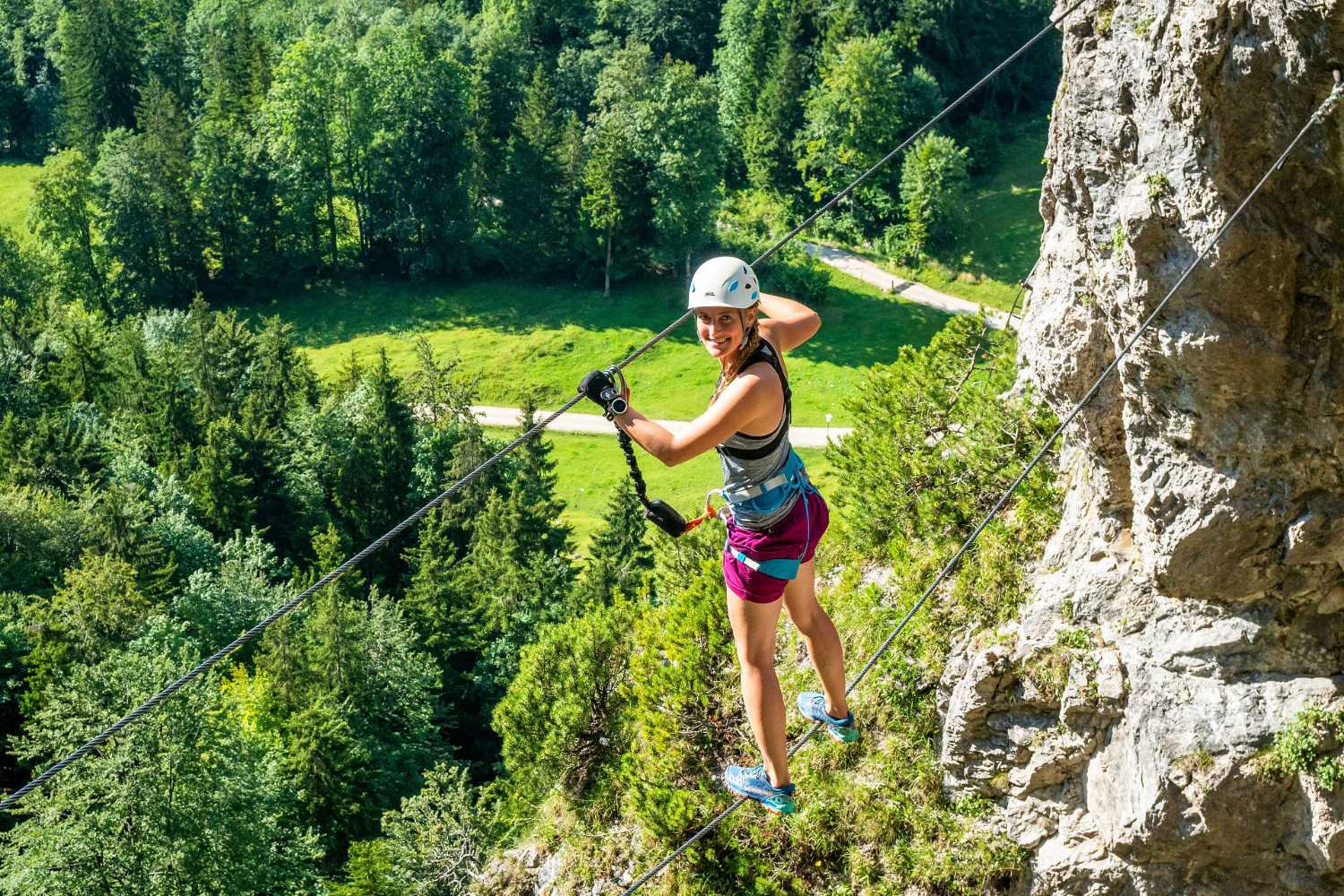 Klettersteig im Kaiserwinkl in Tirol: gesicherter Quergang am Fels mit Talblick