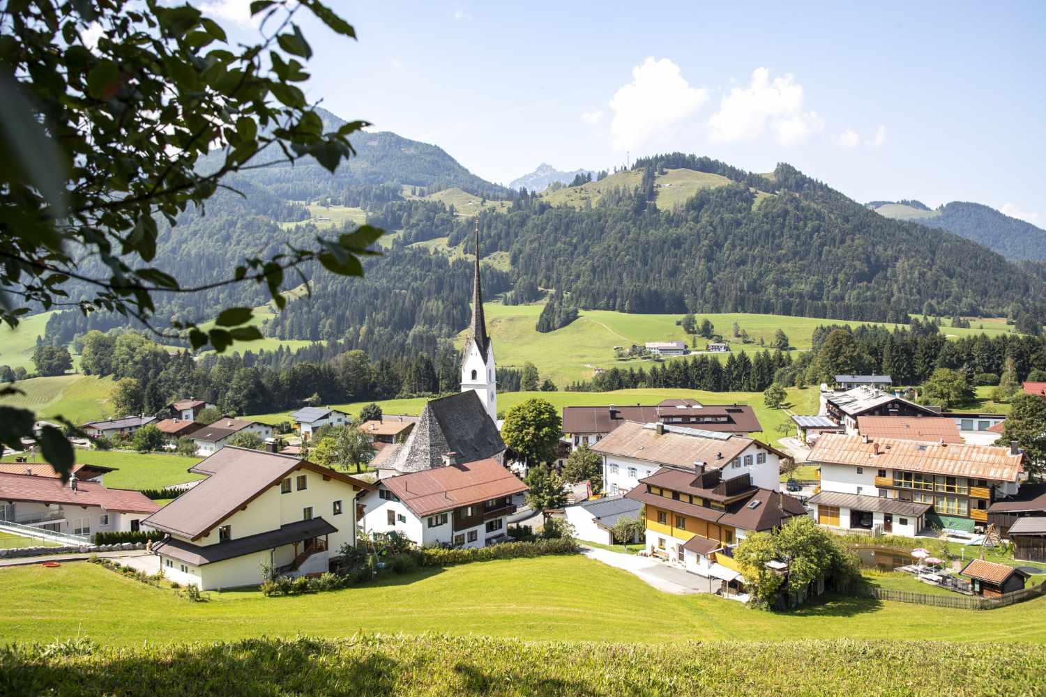 Schwendt im Kaiserwinkl in Tirol mit Kirche und Bergpanorama im Sommer