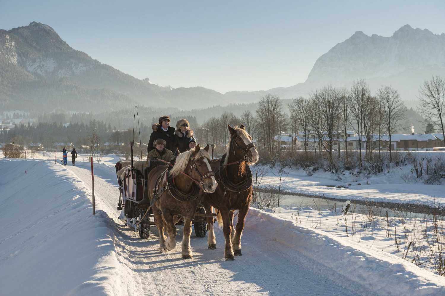 Pferdeschlittenfahrt durch verschneite Landschaft im Kaiserwinkl in Tirol mit Bergpanorama