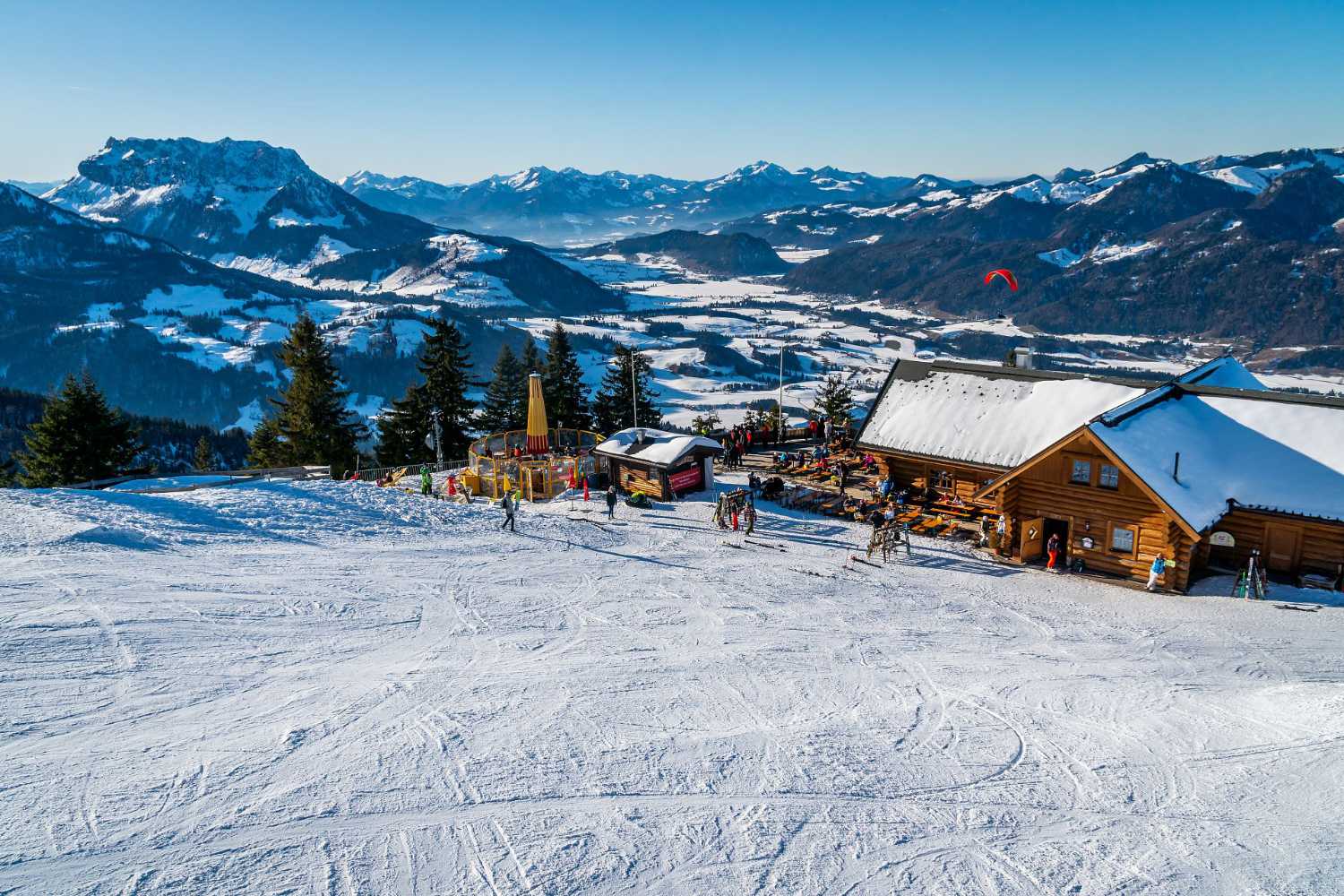 Skihütte an der Piste mit weitem Blick ins Tal und Berge im Kaiserwinkl